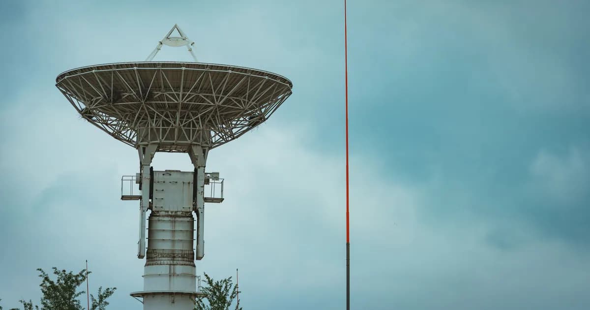 Large satellite dish tower standing tall under a cloudy sky