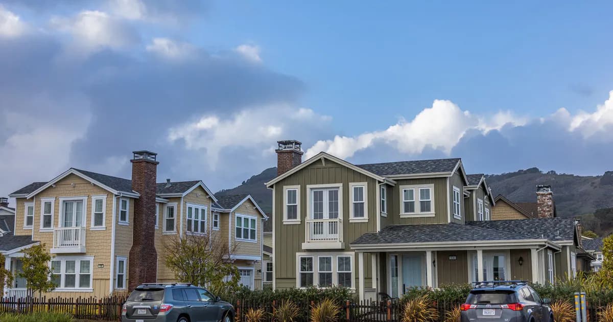 Picturesque suburban neighborhood with modern houses and parked cars under a partly cloudy sky