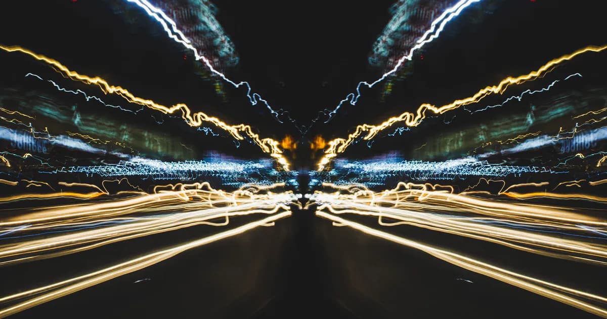 Long exposure capture showing vibrant light trails, creating a dynamic cityscape effect at night