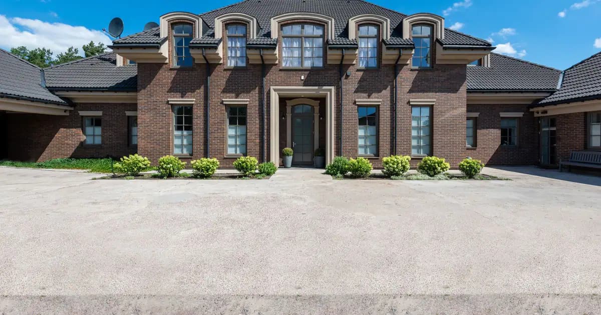 Elegant two-story brick house exterior with classic architecture under a bright blue sky