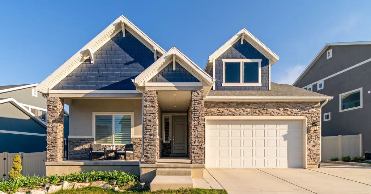 A charming modern suburban home with a stone facade and a neatly maintained lawn