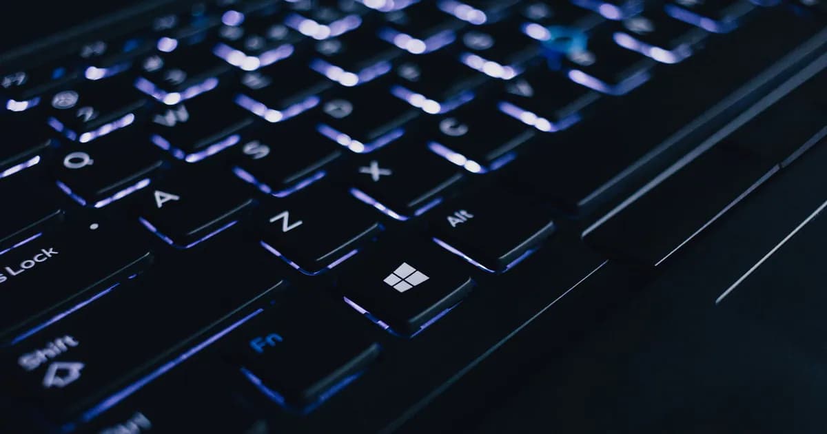 Detailed view of an illuminated laptop keyboard showing individual keys and backlight effect