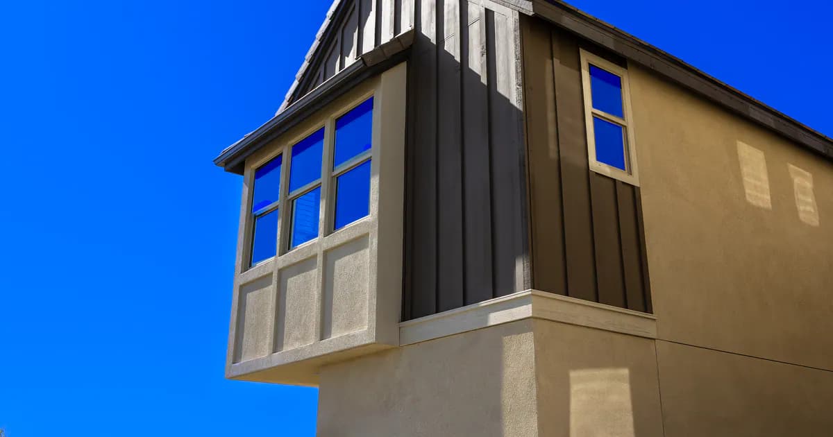 Low angle shot of a modern residential building facade against a clear blue sky