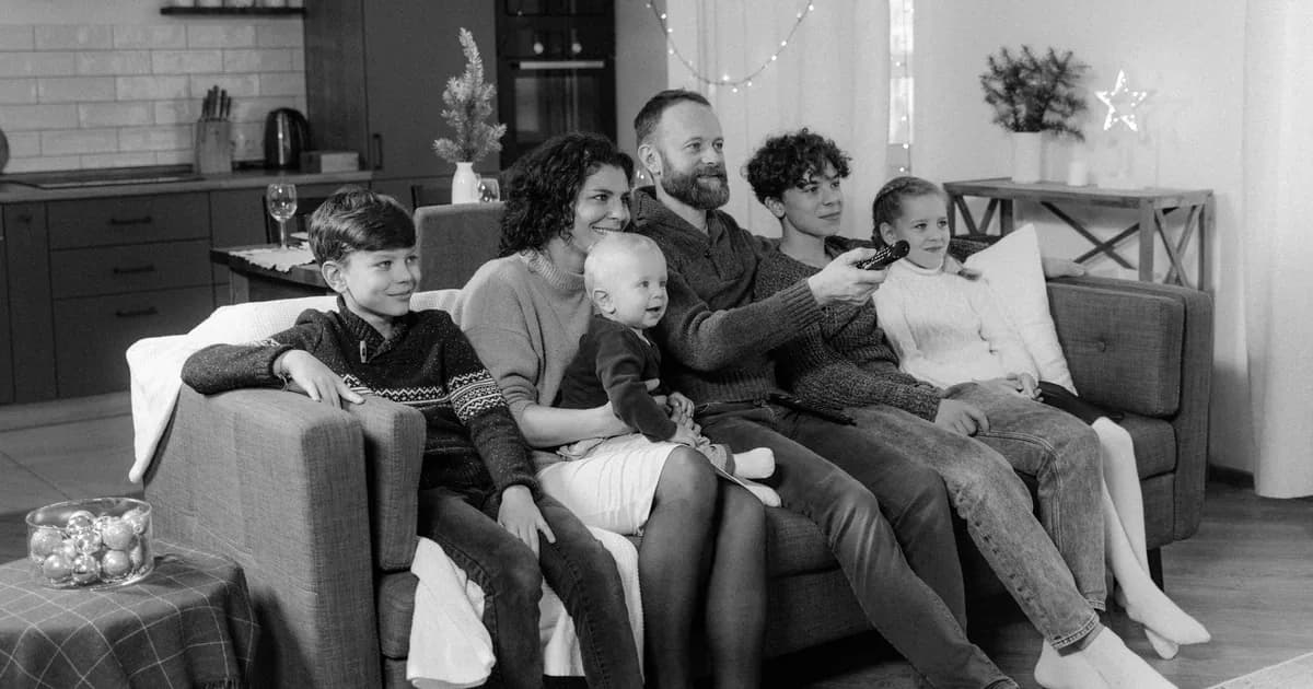 A happy family of six enjoying a cozy time together at home in a monochrome setting