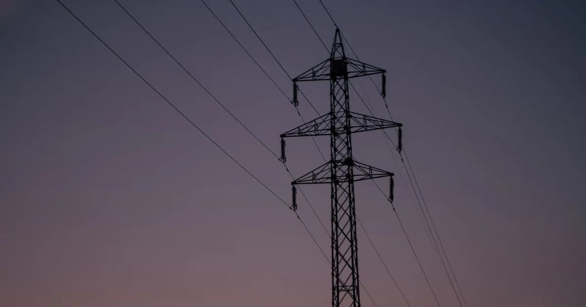 Silhouette of an electric tower against a twilight sky