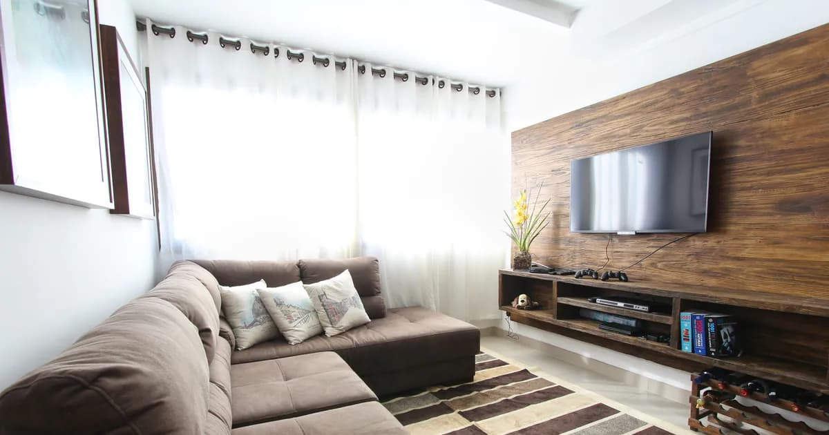 Stylish modern living room featuring a brown sofa, wall-mounted TV, and interior decor