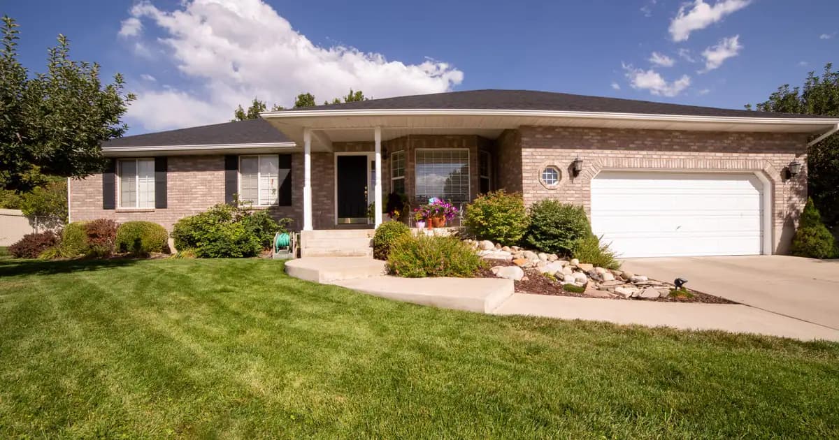 A modern suburban house exterior with a beautiful landscaped yard on a sunny day