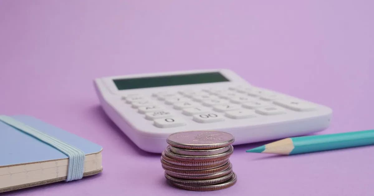 Calculator, coins, and stationery symbolize budgeting and finance on a pastel purple backdrop