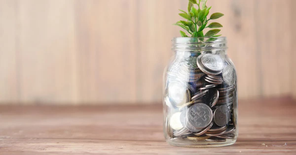 A jar filled with coins and a plant symbolizes growth in savings and investment