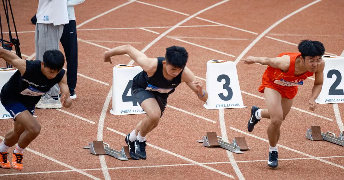 Young male sprinters launching off at the starting line