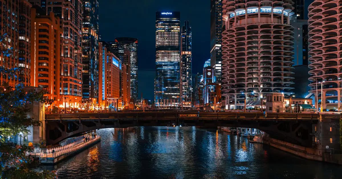 A captivating night view of the Chicago River flanked by towering skyscrapers and illuminated city lights