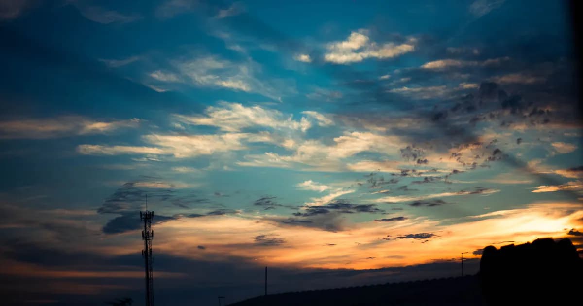 Scenic sunset sky with colorful clouds and silhouetted landscape