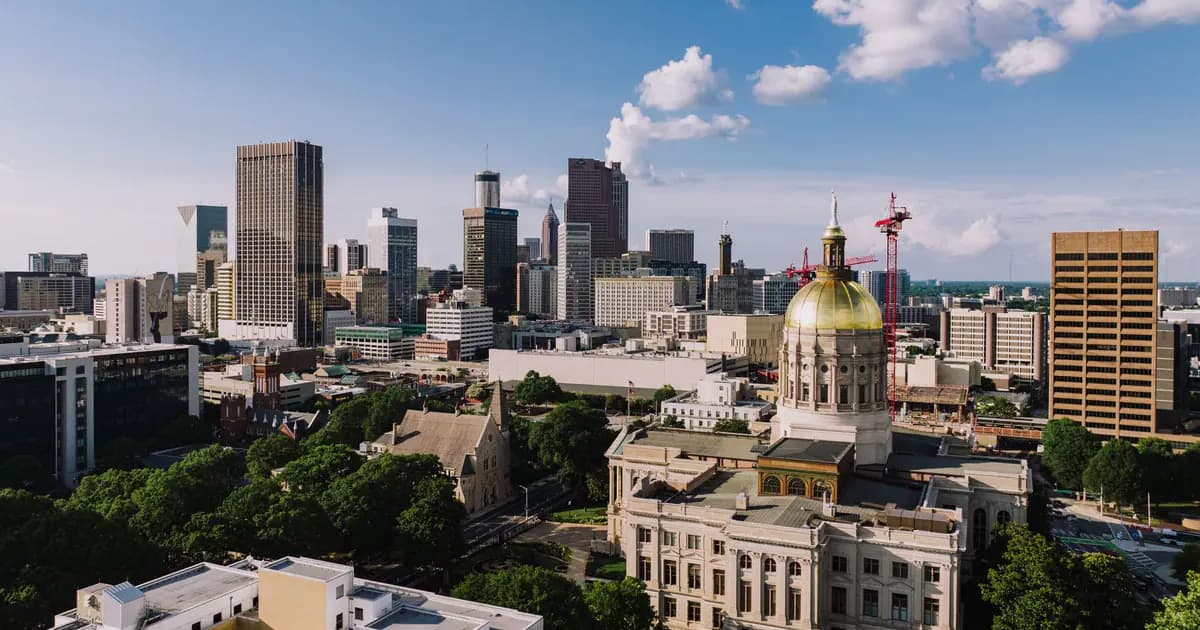 A breathtaking aerial view capturing the Atlanta skyline and the Georgia State Capitol under a clear blue sky