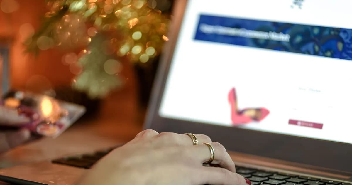 Close-up of a hand using a laptop keyboard while holding a credit card