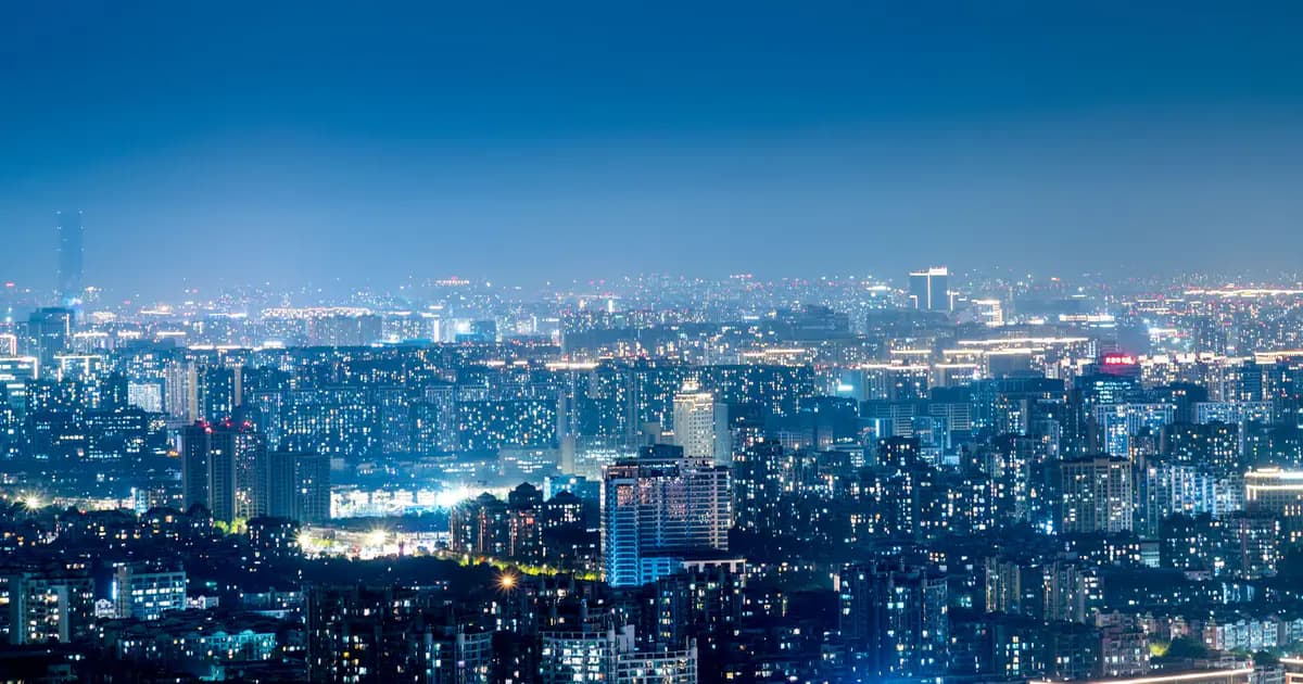 Panoramic view of a bustling city skyline illuminated at night