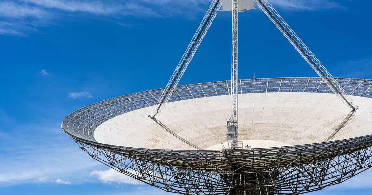 A large satellite dish with a clear blue sky in the background