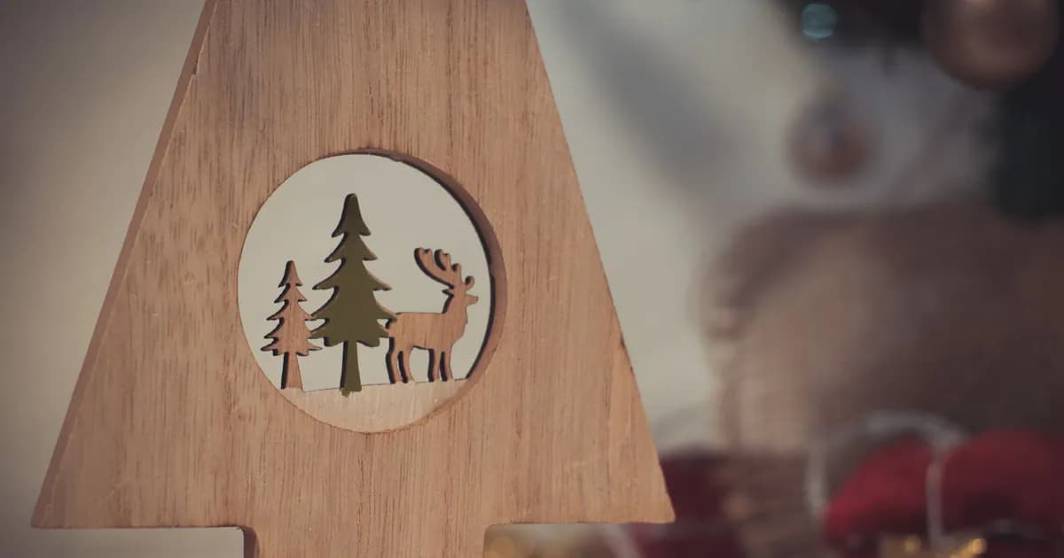 A charming wooden Christmas decoration featuring a reindeer and pine trees