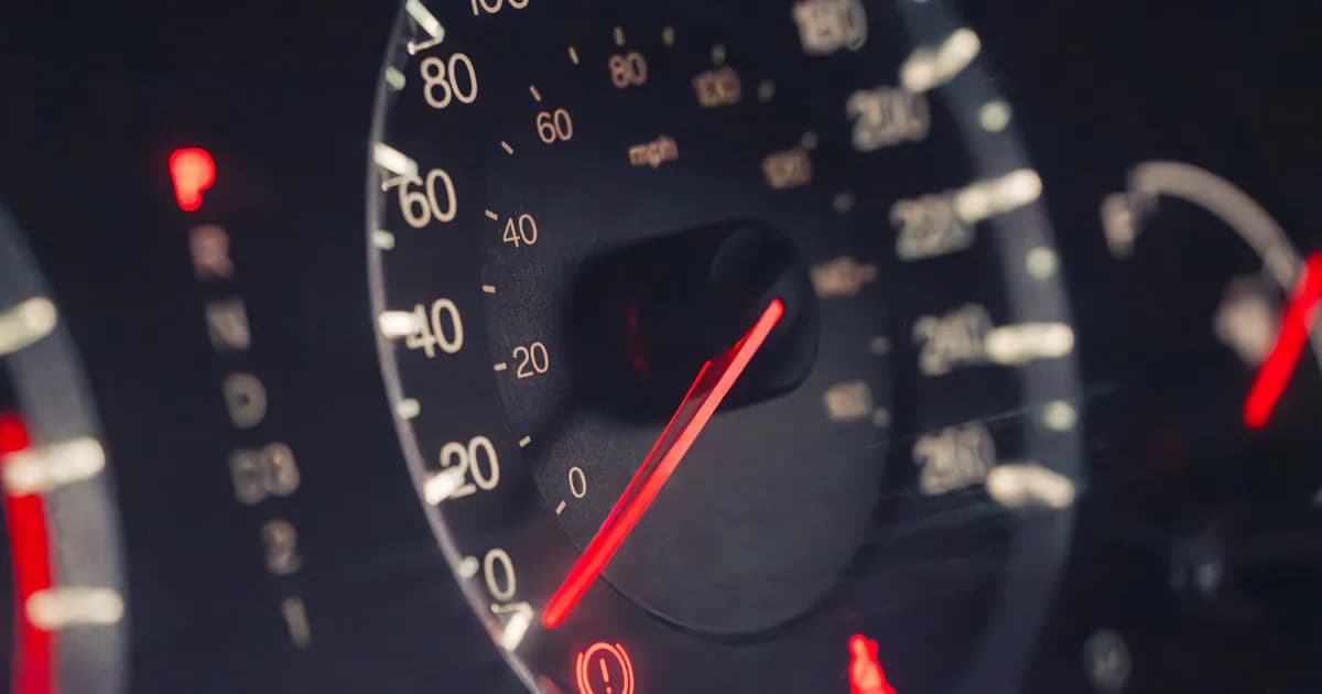 Detailed view of a car speedometer showing km/h and mph in low light settings