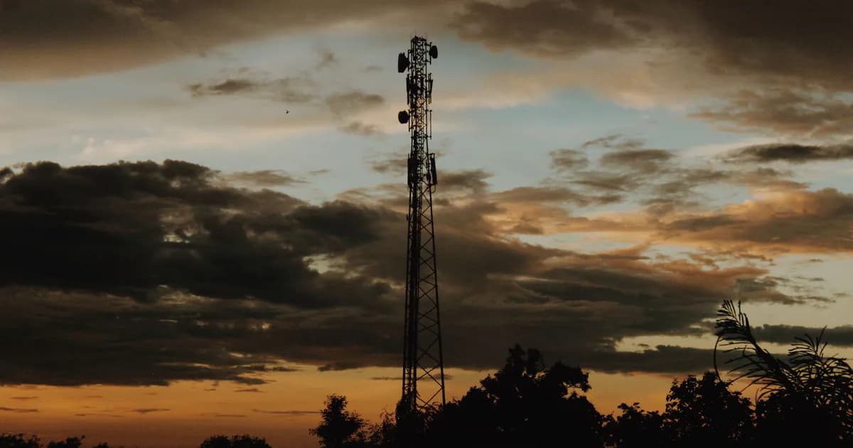 A striking silhouette of a cell tower against a dramatic sunset sky