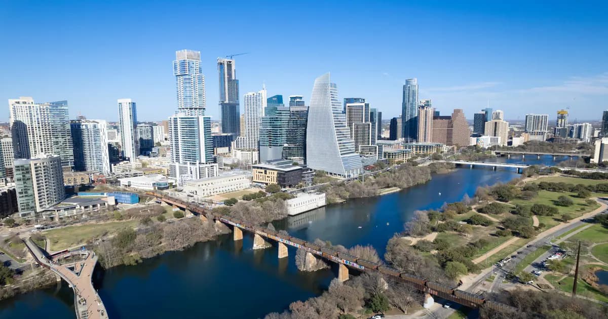 Aerial view of Austin, Texas skyline with landmarks including river and footbridge