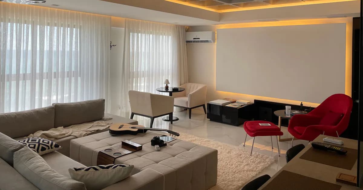 Spacious minimalist living room with natural light, featuring cozy seating and a ceiling projector