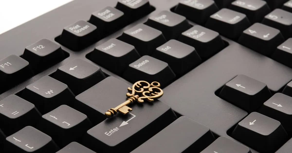 Close-up of an ornate vintage key placed on a modern computer keyboard