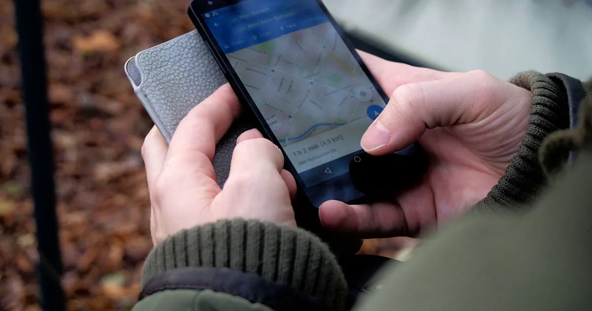 Close-up of hands using a map app on a smartphone outdoors