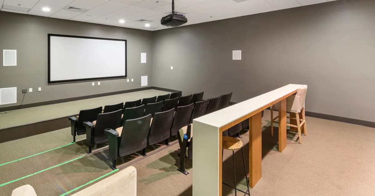 Spacious and modern empty cinema room with rows of comfortable chairs and a large screen