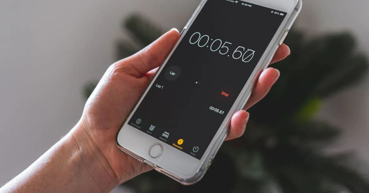 Close-up of a hand holding a smartphone with a stopwatch app running
