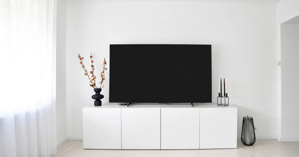 A sleek and minimalist Scandinavian living room with white decor and electronics